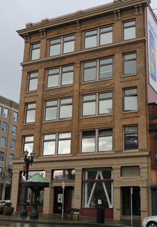 A brown building with a green awning and a sign that says "Commerce Blog".