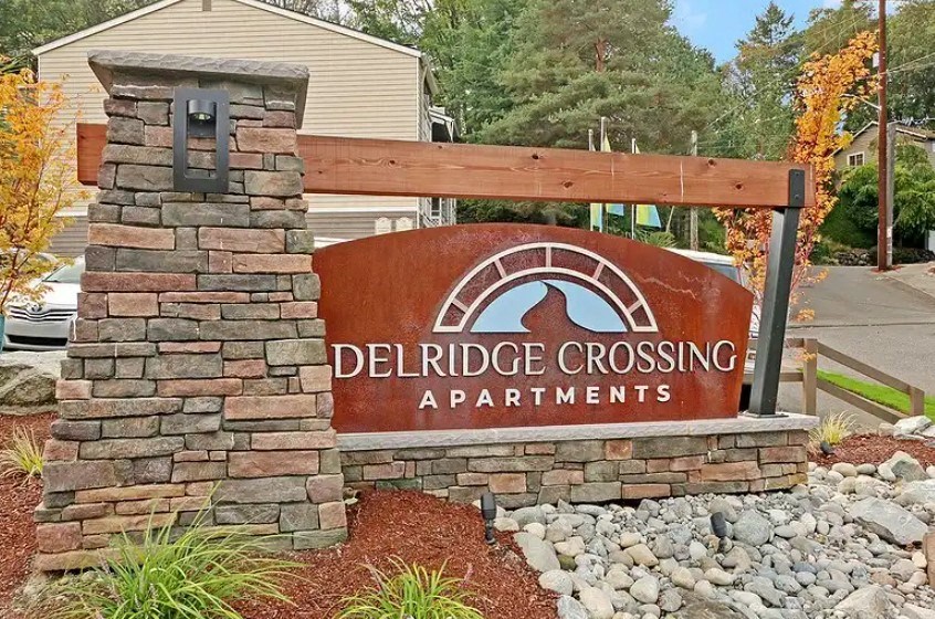 A sign for Delridge Crossing Apartments is displayed in front of a building.