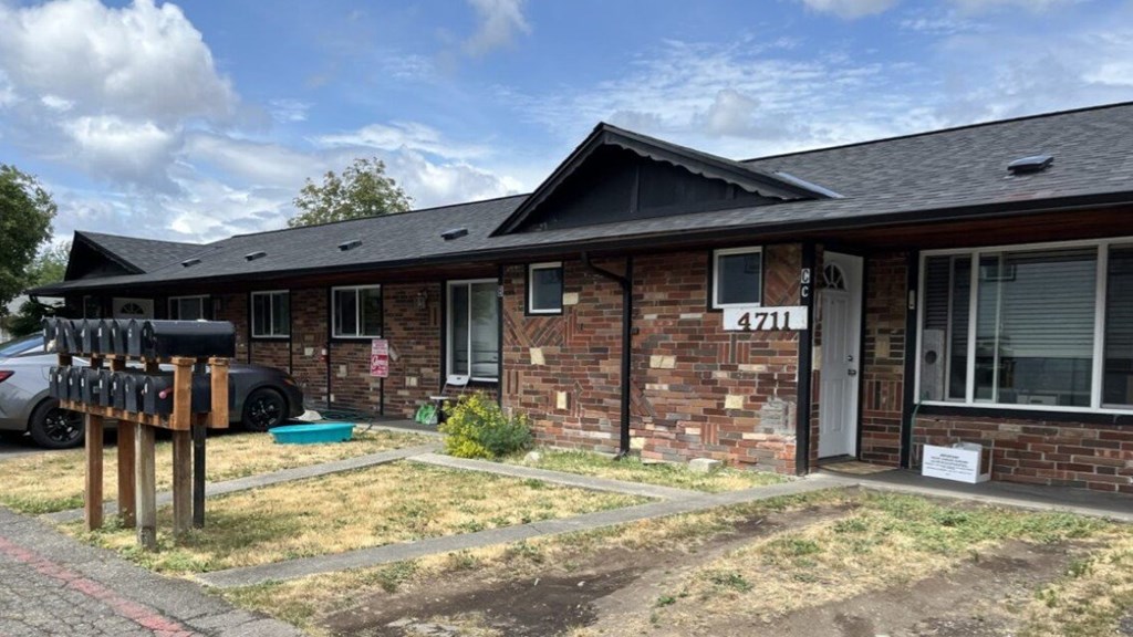 A brick house with a white door and mailbox.