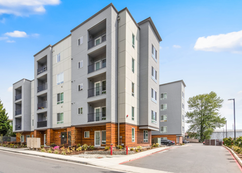 A modern apartment building with a red brick entrance.