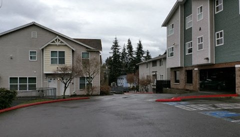 A parking lot in front of apartment buildings.