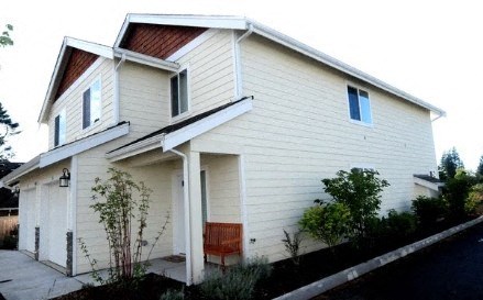 A small white house with a red bench in front.