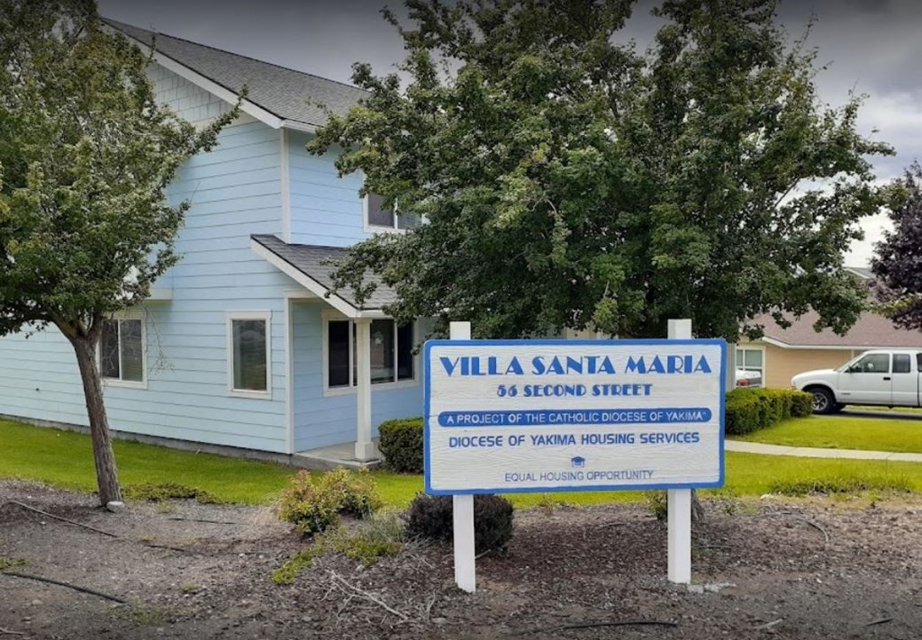 a sign for villa in front of a blue house