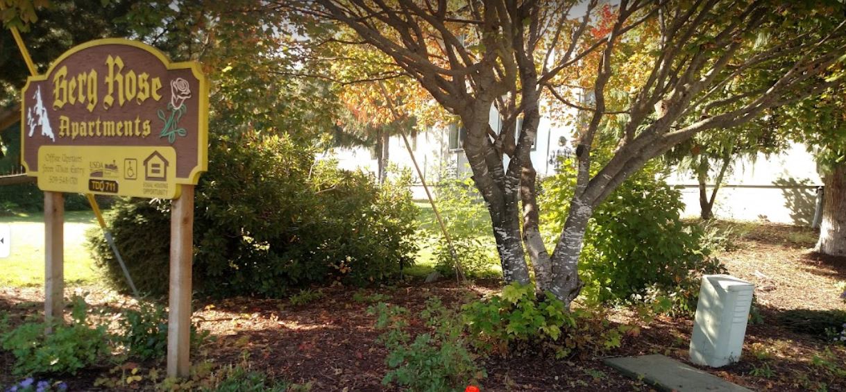 a sign for the east ridge apartments is in front of a tree