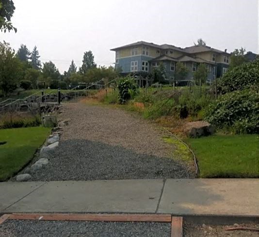a gravel path with a house in the background