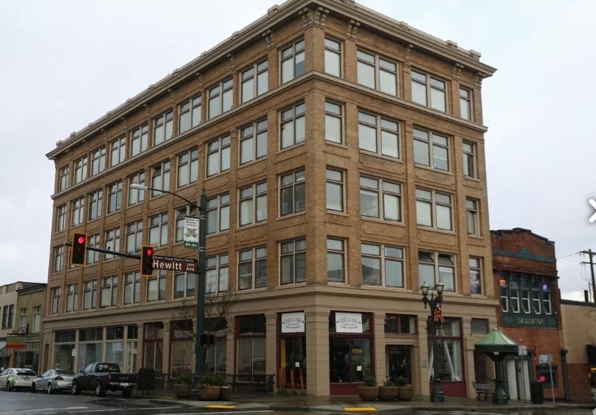 A large brown building with many windows is in the foreground.