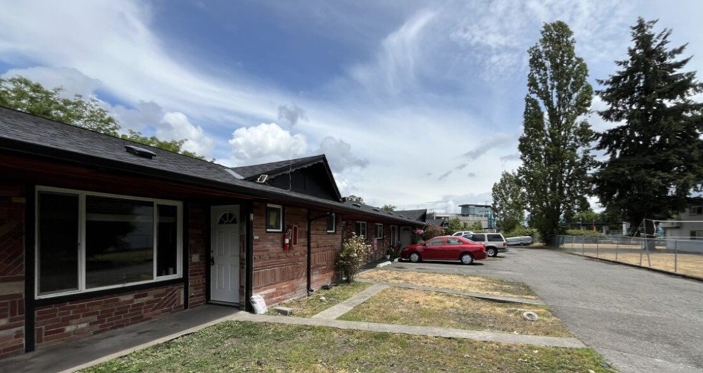 A red car is parked in front of a house.