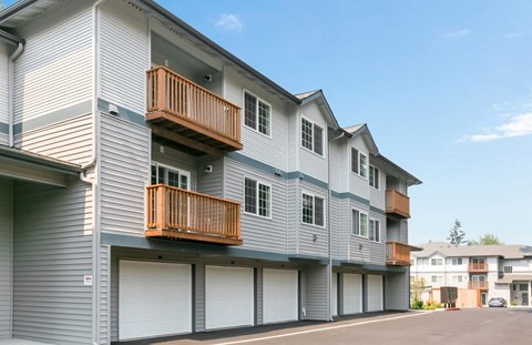 A grey apartment building with a balcony on the second floor.