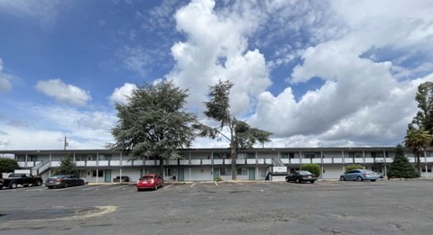 A parking lot with cars and a building in the background.