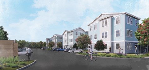 A street view of a residential area with houses and parked cars.