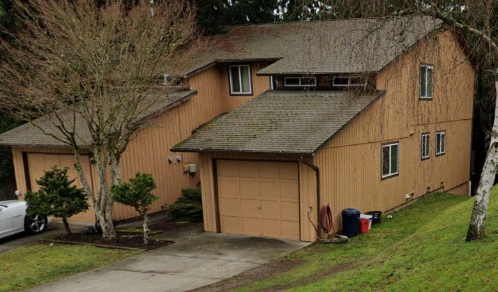 A large two-story house with a garage and a driveway.