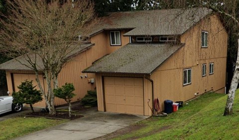 A large two-story house with a garage and a driveway.