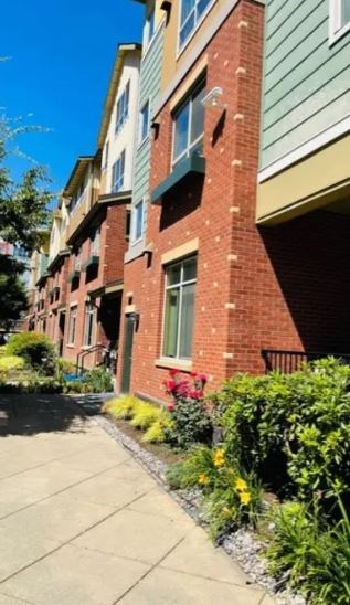A row of apartment buildings with green trim and red brick.