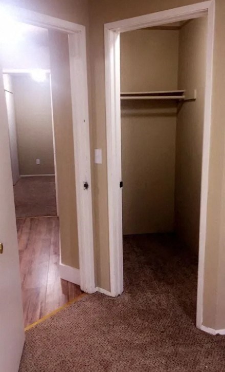 a hallway with a closet and a door open