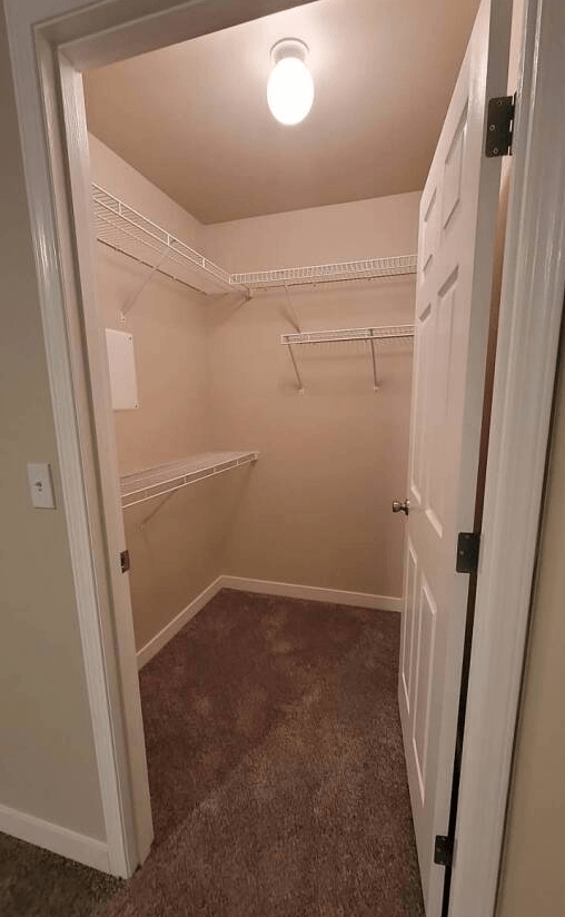 a small room with a white closet and a door