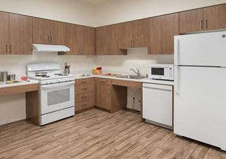 a kitchen with white appliances and wooden floors