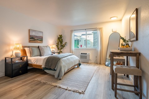 a bedroom with a bed and a desk with a mirror