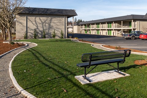 a park bench sitting on the grass in front of a building