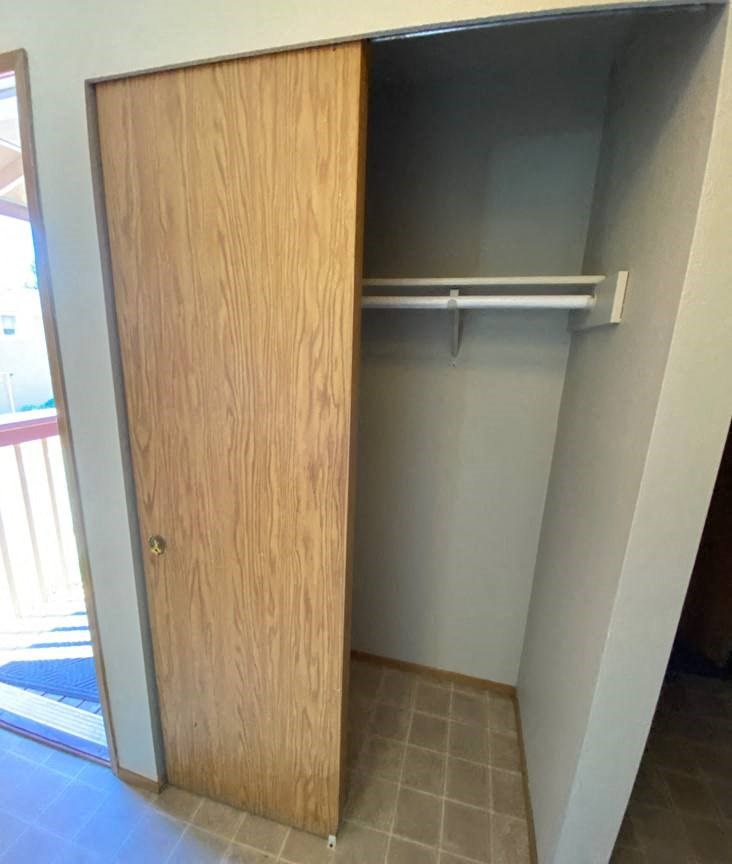 an empty closet in a room with a door open