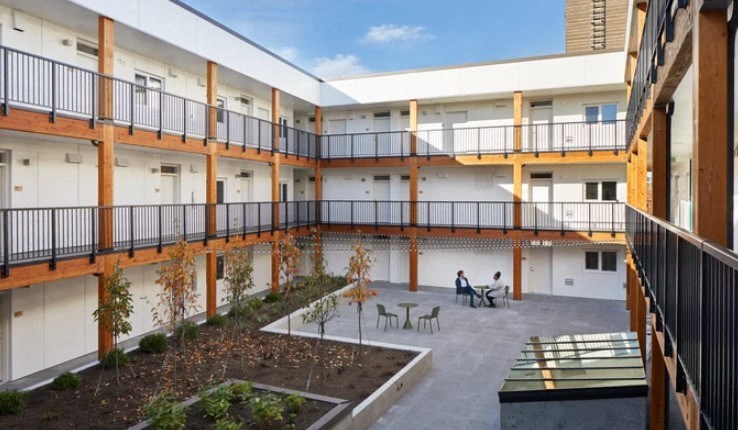 A courtyard with a few people sitting and chatting.