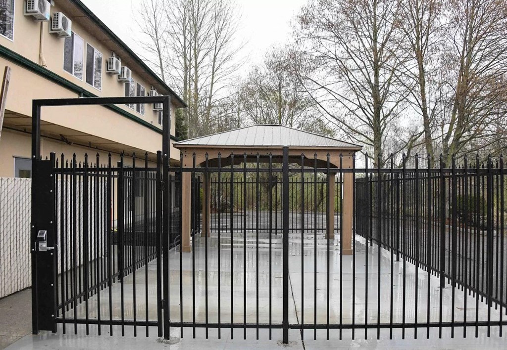 a fence with a gazebo in front of a house