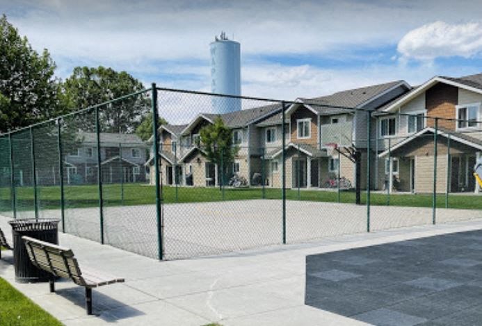a tennis court with houses in the background