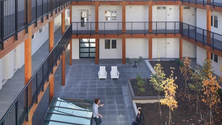 A courtyard with a glass roof and people walking around.