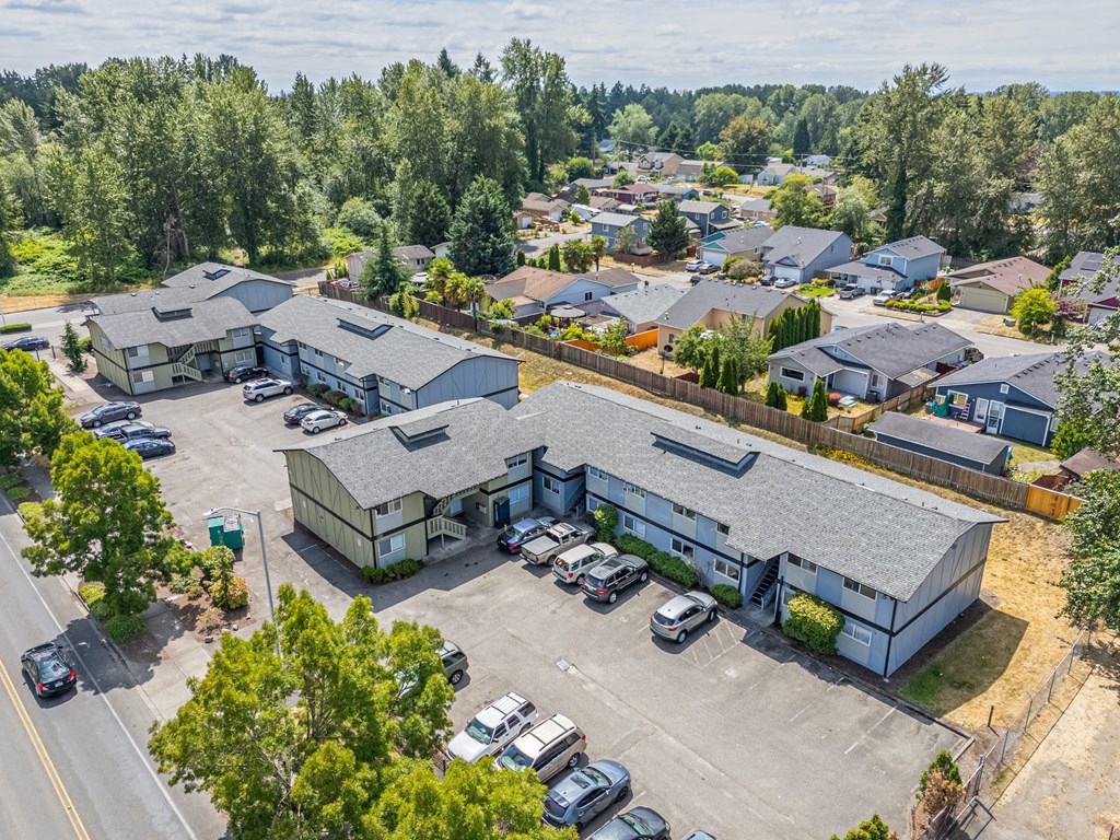 A bird's eye view of a residential area with houses and parked cars.