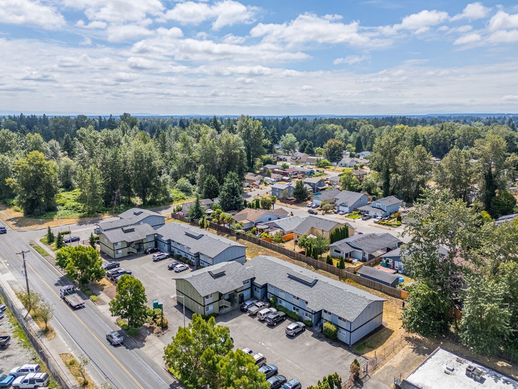 A bird's eye view of a residential area with houses and parked cars.