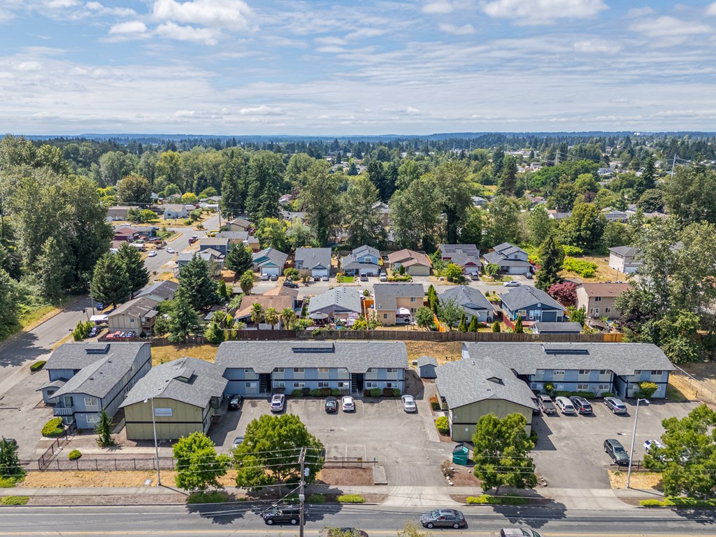 A bird's eye view of a residential area with houses and parked cars.