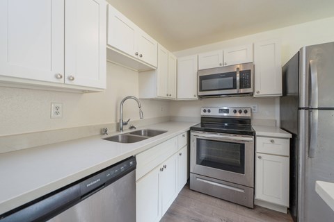 A kitchen with white cabinets and stainless steel appliances.