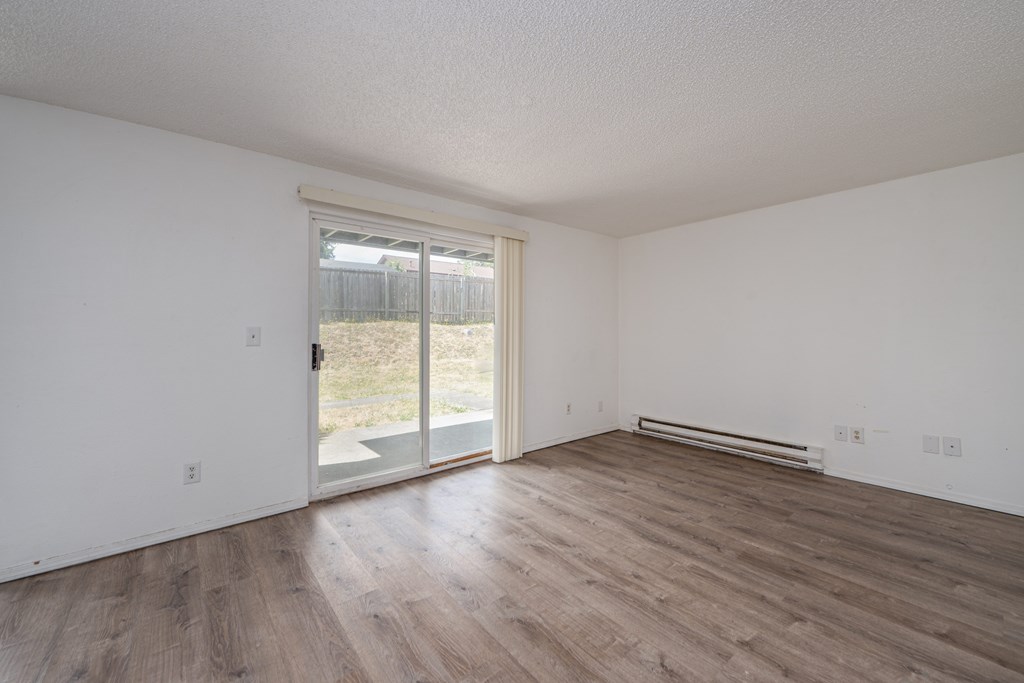 A room with a sliding glass door leading to a backyard.