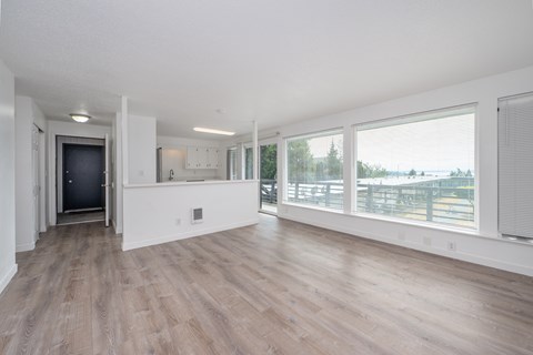 A spacious room with wooden floors and white walls.