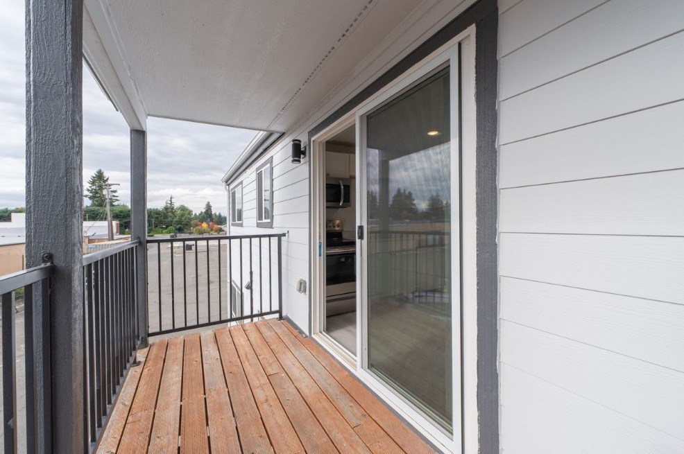 A balcony with a sliding glass door and a black railing.
