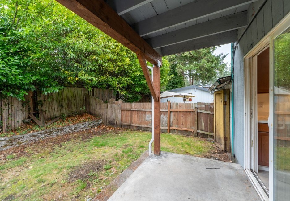 A backyard with a wooden fence and a shed.