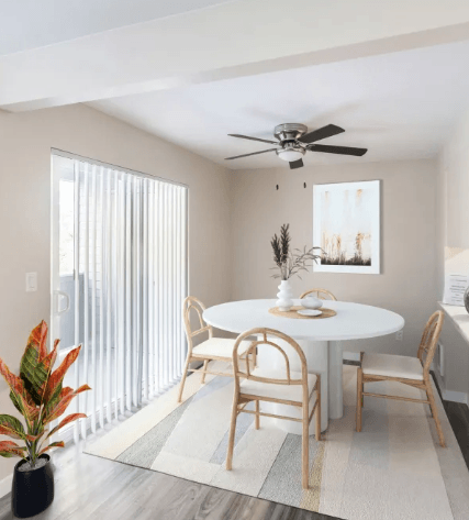 A dining room with a white table and chairs.
