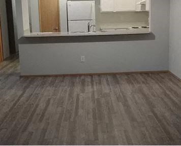 an empty room with a sink and a mirror