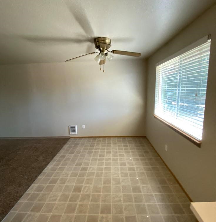 a living room with a ceiling fan and a window