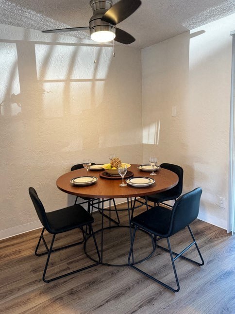 A dining table with four chairs around it.
