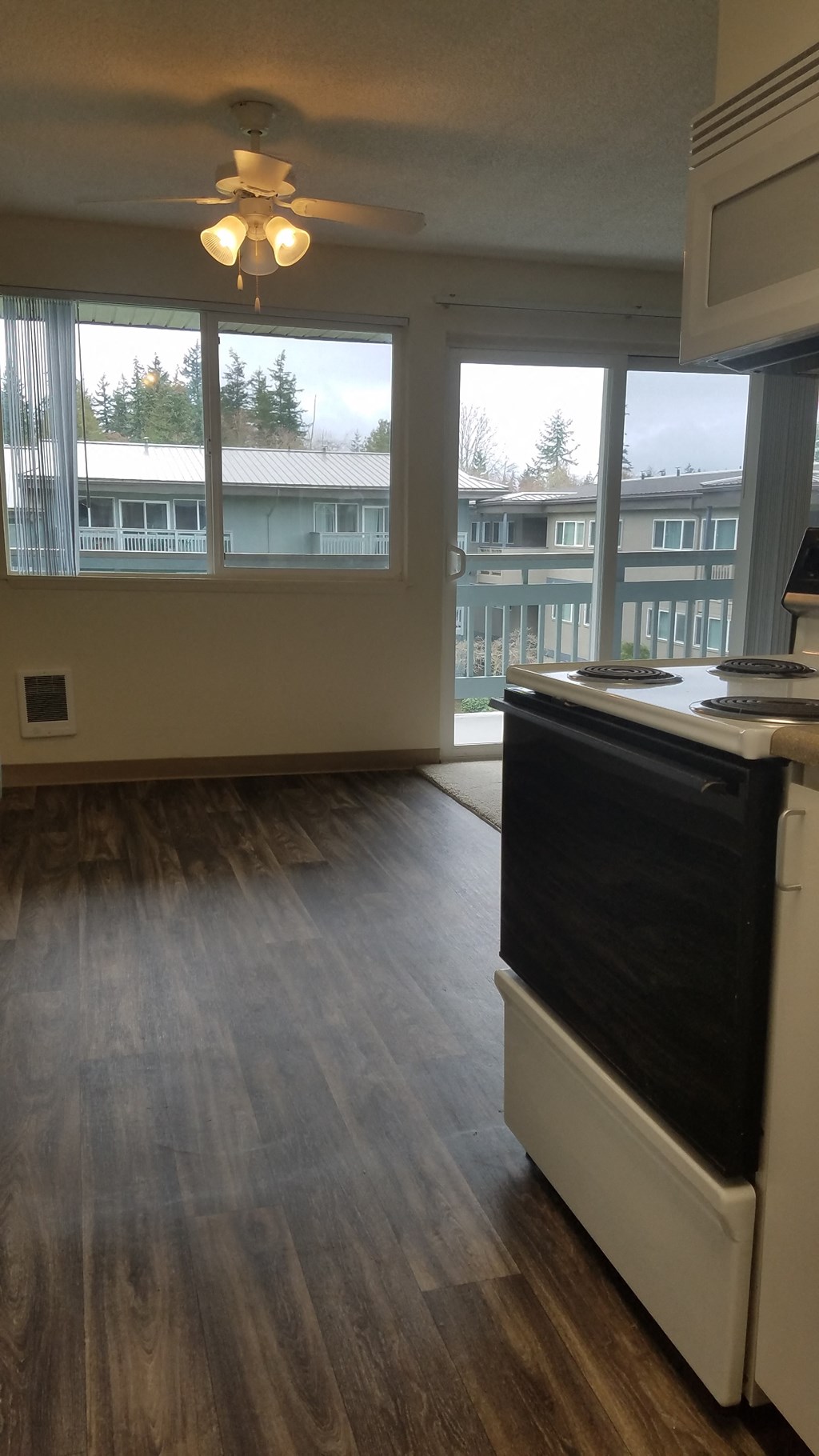A kitchen with a black oven and wooden floors.