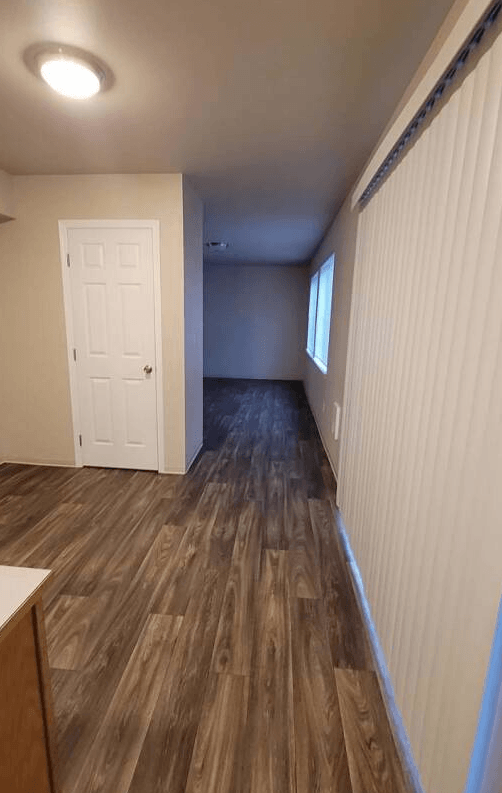 a empty room with a white door and wood floors