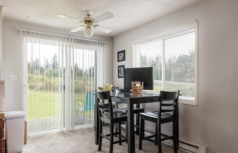 a dining room with a table and chairs and a ceiling fan