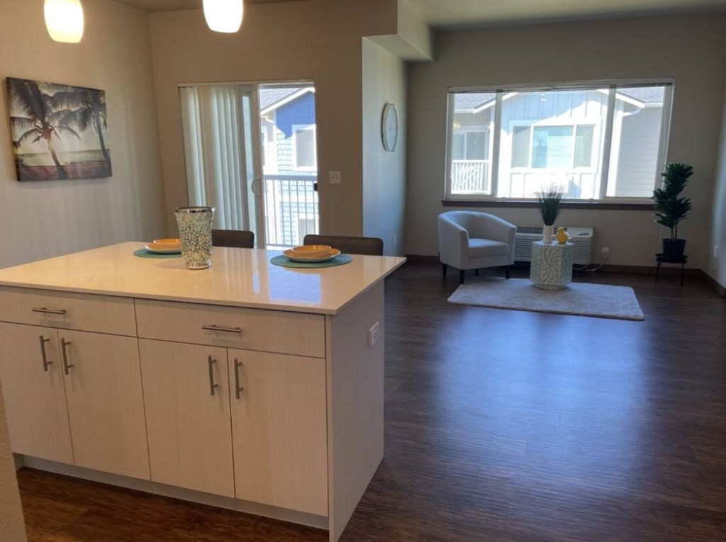 a kitchen and living room with a ceiling fan