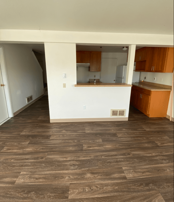 an empty living room and kitchen in an empty house