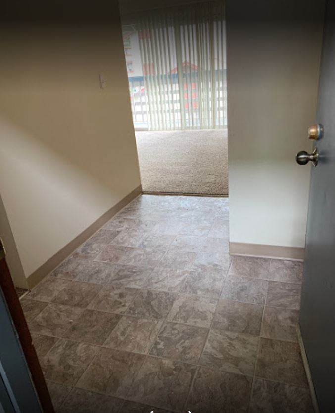 an empty room with a sliding glass door and a tile floor