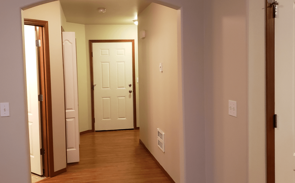 an empty room with a door and a hallway