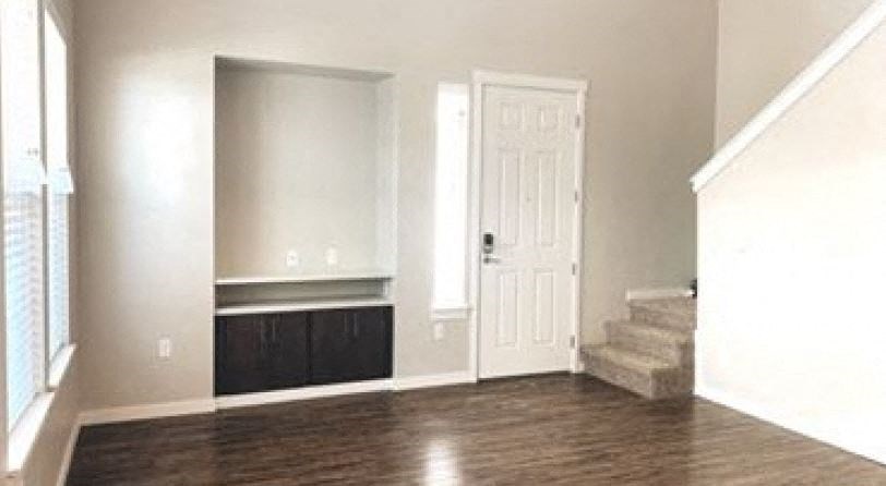 a empty living room with a door and stairs