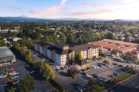 A parking lot is in the foreground of a city with a mountain in the background.