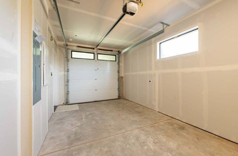 A spacious garage with a white door and a window.