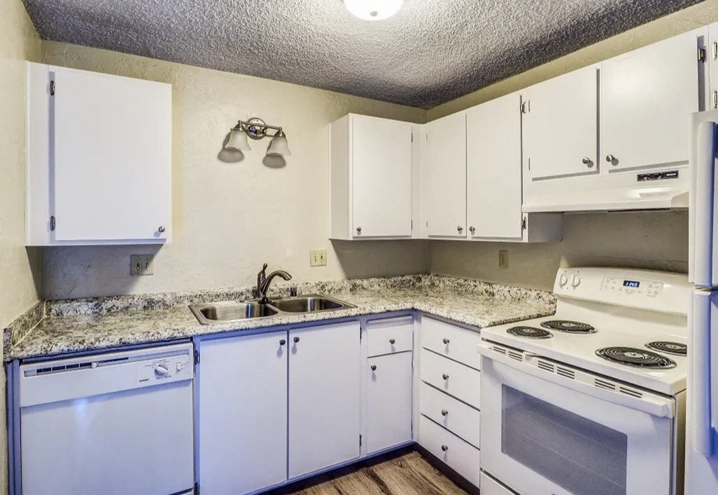 a kitchen with white appliances and white cabinets